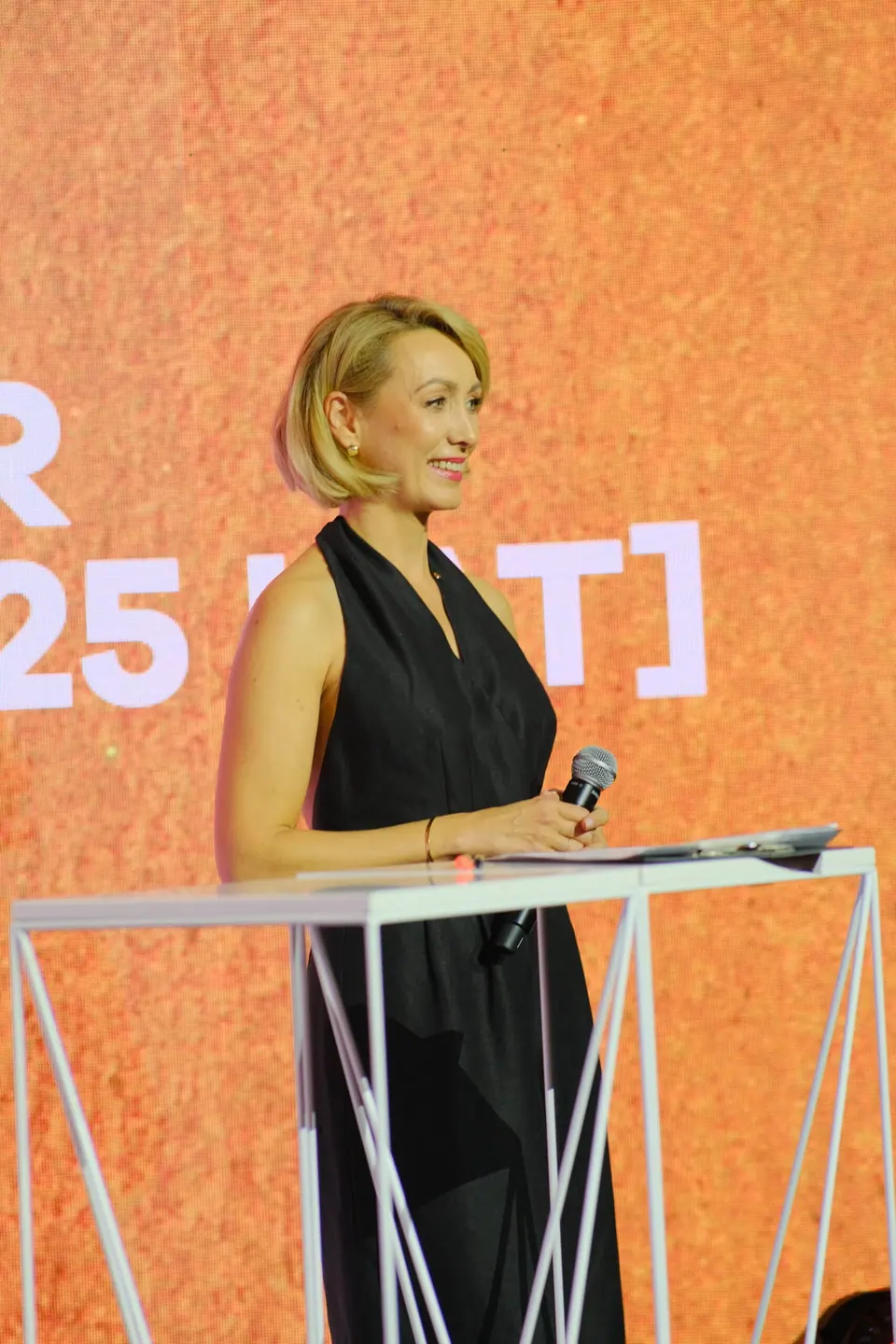 Prowadząca Galę 2023 na tle ekranu