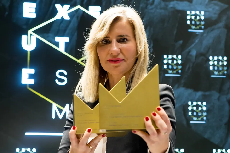 A winner holding golden Marketing Director of the Year statuettes